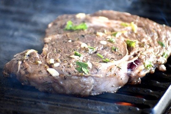 raw ribeye steak on grill