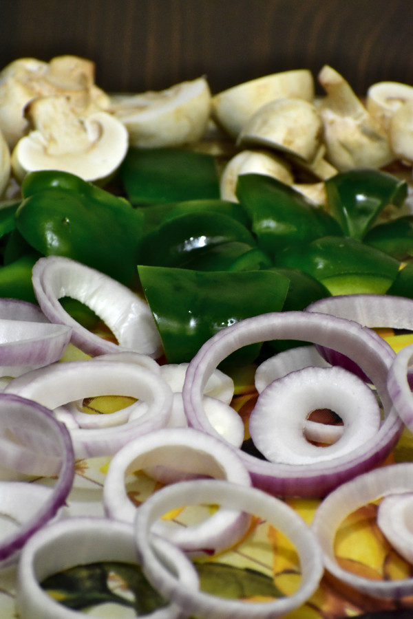 side view of chopped onions, green bell peppers and mushrooms