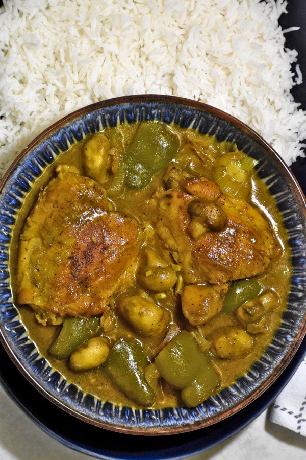 overhead shot of blue bowl full of south african chicken curry with rice above