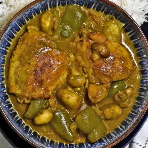 close up overhead shot of south african chicken curry in a blue bowl
