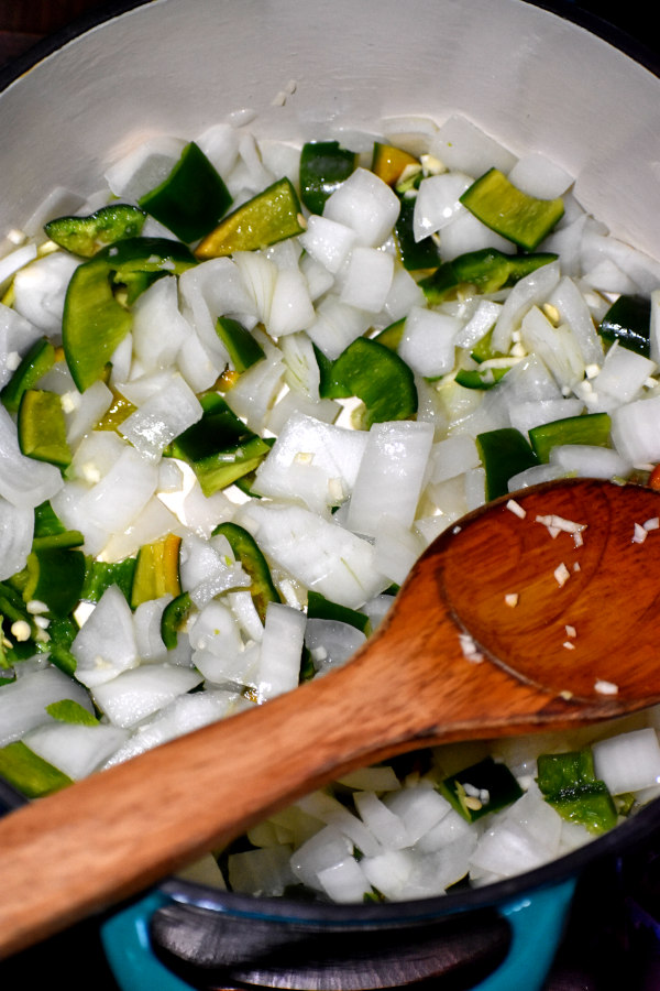 洋葱,大蒜和波布拉诺椒辣椒呈深绿色荷兰烤肉锅做饭