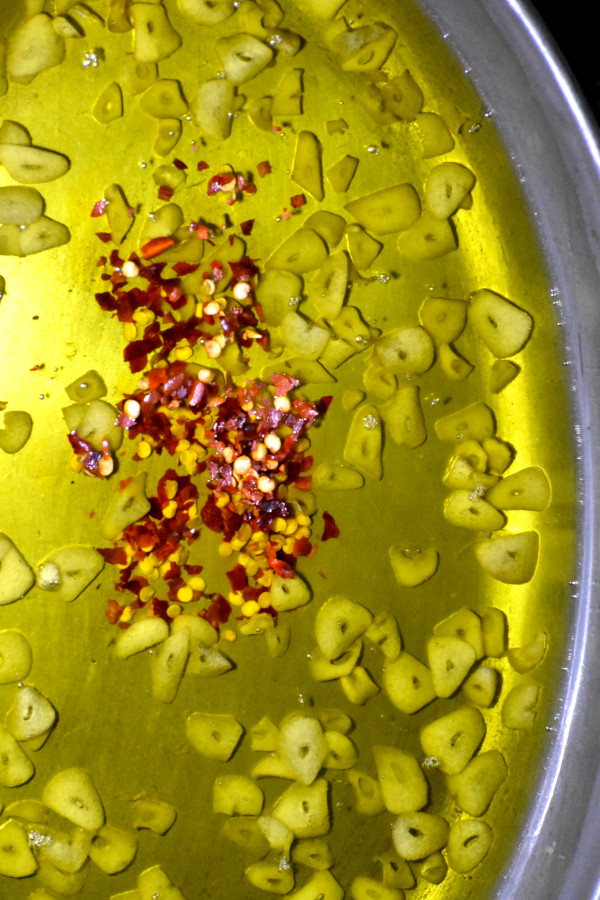 红辣椒片添加到有大蒜味的油混合物。