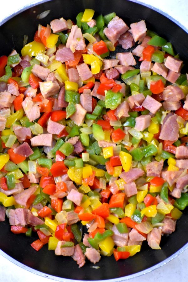 火腿丁，洋葱和彩色灯笼椒放入煎锅中。