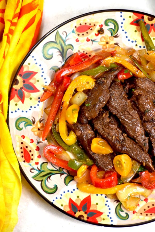 煮熟的肉放在煮熟的洋葱和辣椒上，放在吉普赛盘子里。